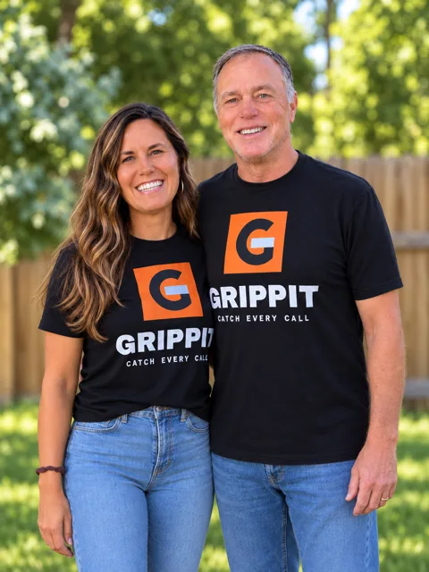 Lee and Eva Brady wearing black Grippit shirts, standing together in front of a green backyard fence.